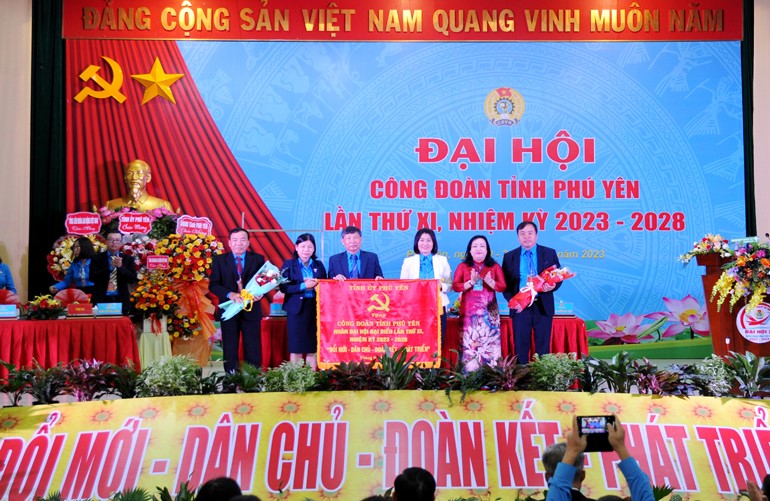 Thay mặt Tỉnh ủy, đồng chí Cao Thị Hòa An, Phó Bí thư thường trực Tỉnh ủy, Chủ tịch HĐND tỉnh tặng đại hội bức trướng mang dòng chữ “Đổi Mới - Dân Chủ - Đoàn Kết - Phát Triển”. Ảnh: ANH NGỌC